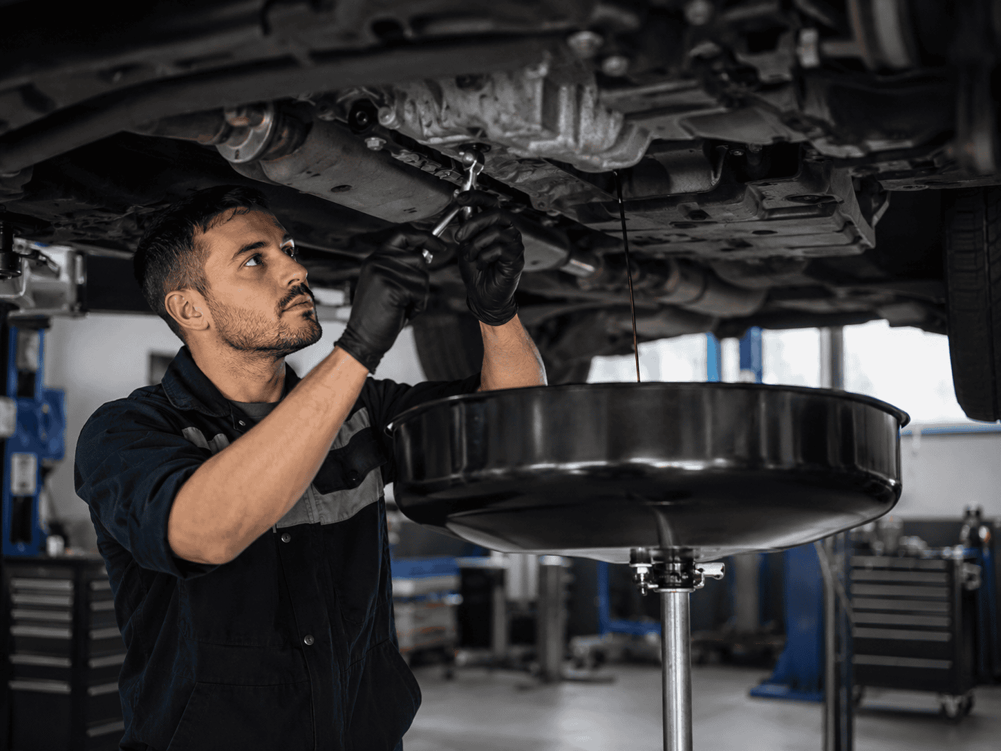 Mechanic inspecting car undercarriage for vehicle recovery in Telford.